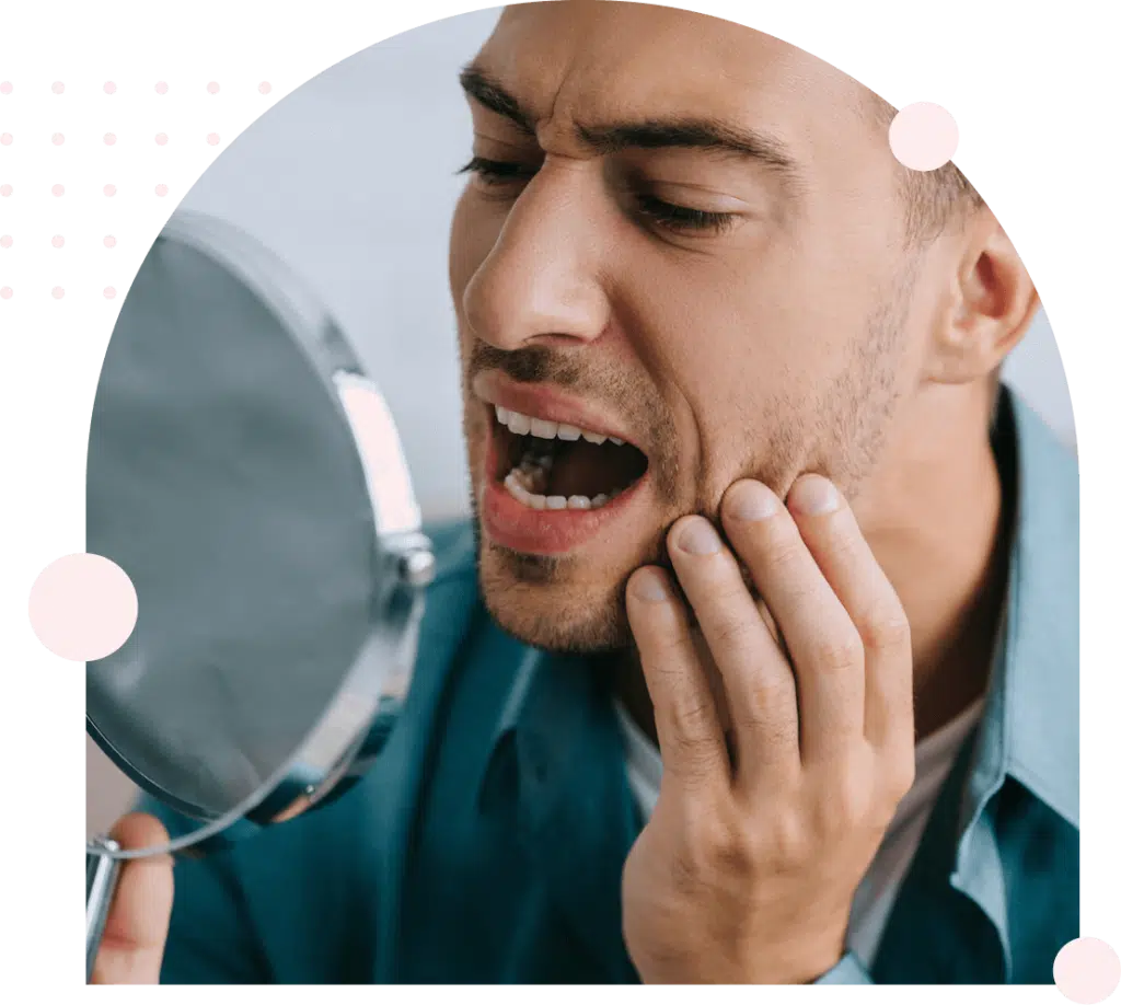Man examining tooth in mirror
