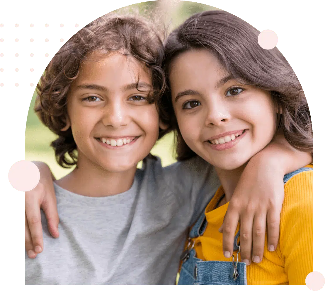 Two smiling children with arms around each other