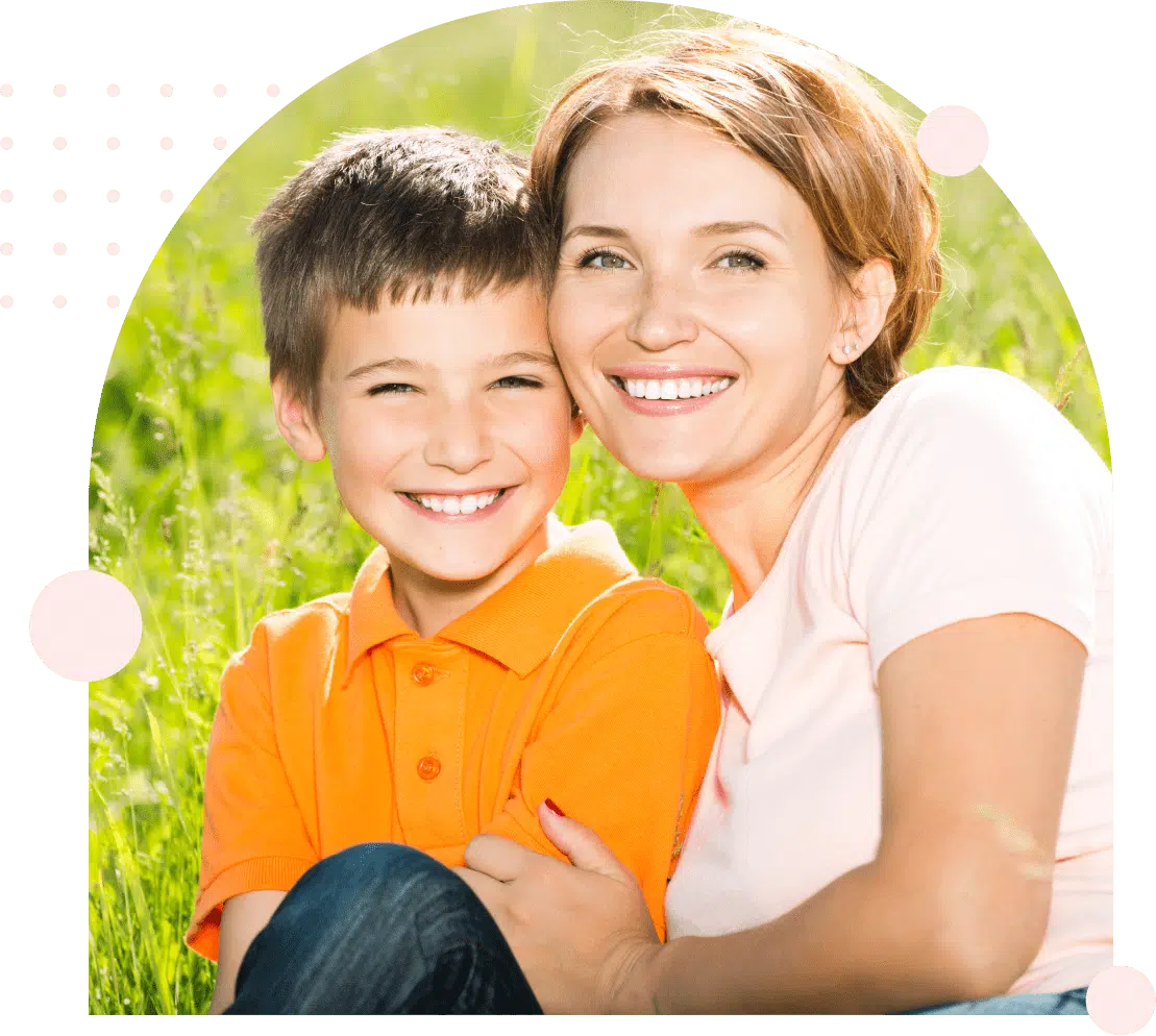 Mother and son smiling in grassy field